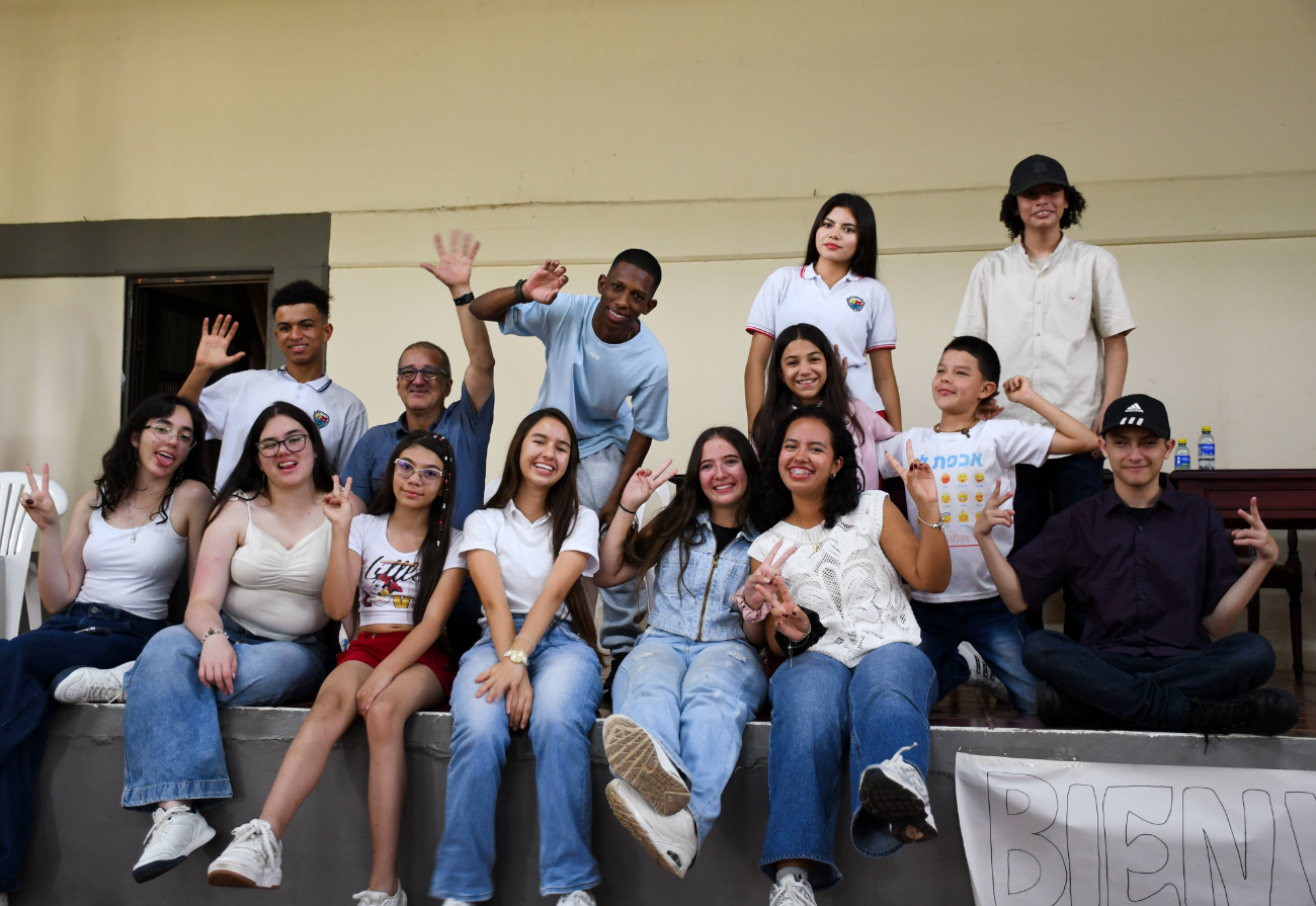 Grupo de niños y niñas posa en la tarima del auditorio.